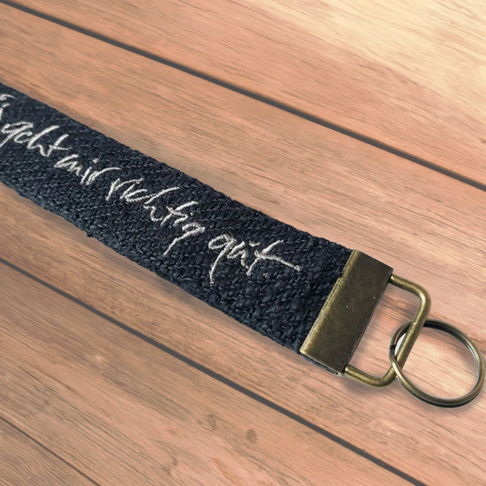 Spiritueller Schlüsselanhänger in Grau mit Motivationsspruch als hochwertige Geschenkidee und nachhaltiges Stoff-Schlüsselband von Signs by Jwala im SignShopTirol.