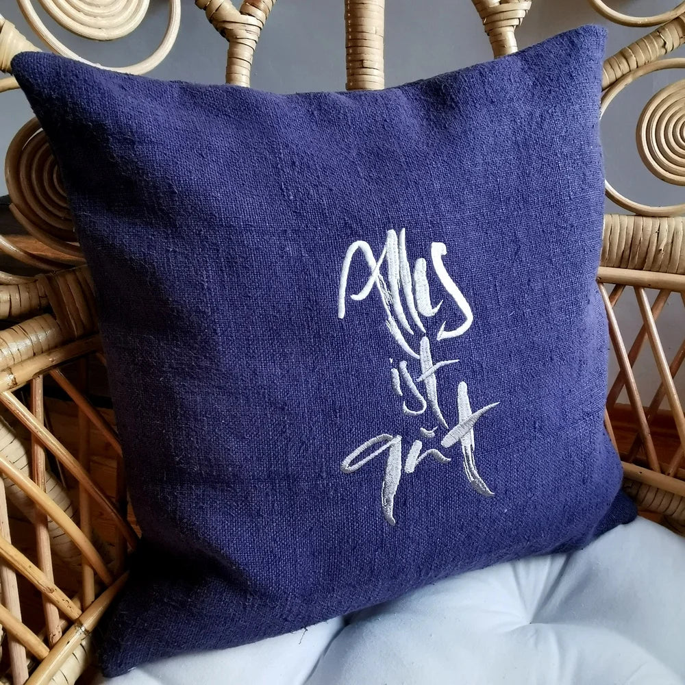 Graublaue Kissenhülle „Alles ist gut“ aus handgewebtem Vintage-Bauernleinen, 40x40 cm, als edles Deko-Unikat auf einem hellen Sofa arrangiert