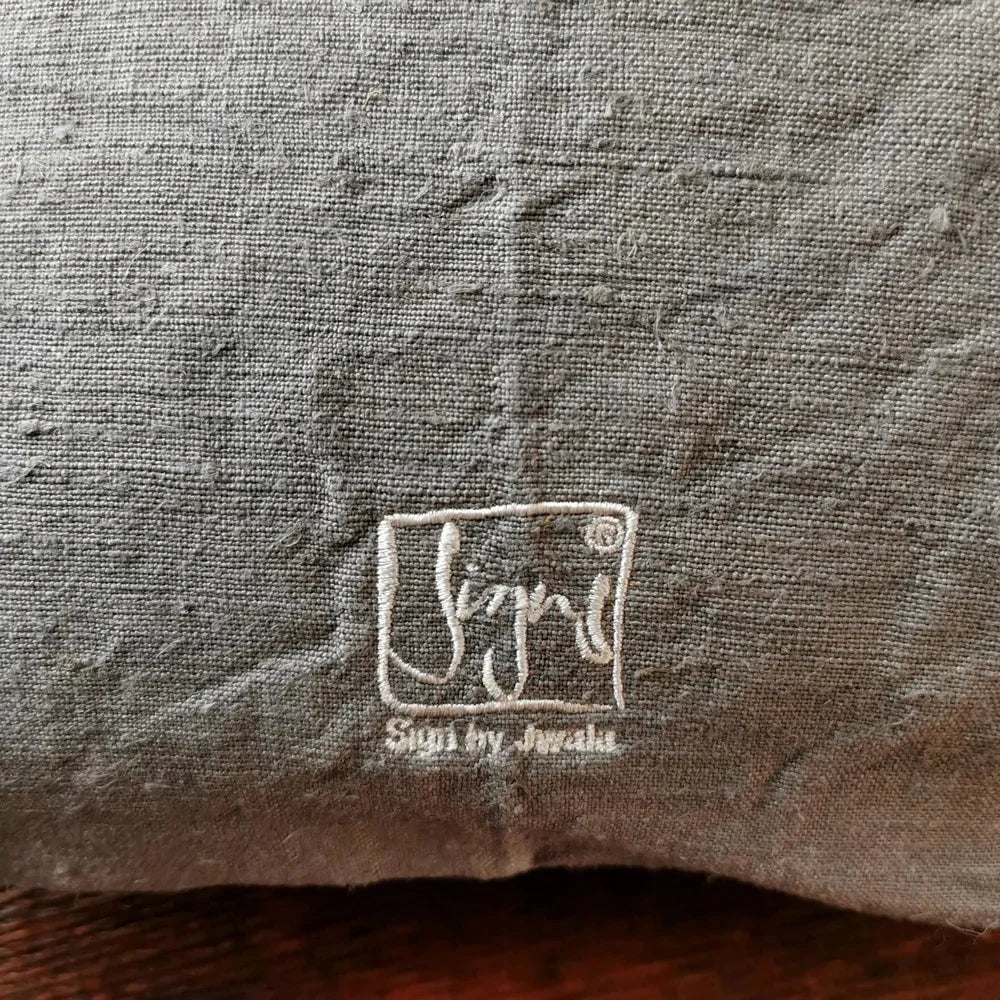 Detailaufnahme der Stickerei „Ich bin eine Meisterin, die übt.“ (Sign by Jwala®) in Silber und Gold auf grauer Bauernleinen-Kissenhülle