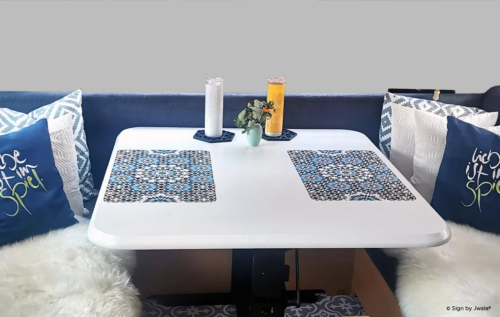 Das Bild zeigt eine gemütliche Sitzecke mit Kissen und einem Poster an der Wand, das eine inspirierende Botschaft trägt. Die Szene wirkt einladend und vermittelt eine warme, positive Atmosphäre, die es im SignShop Tirol zu kaufen gibt