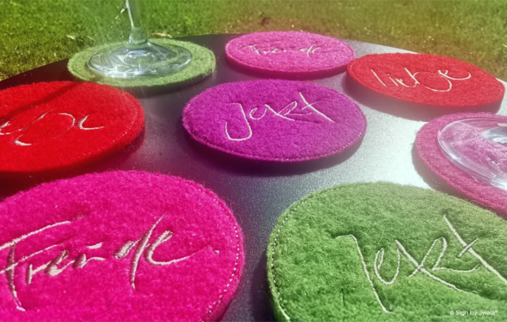 Bunte Glasuntersetzer in Rot, Grün und Rosa aus dem Onlineshop SignShop Tirol – farbenfrohe Akzente für den Tisch.