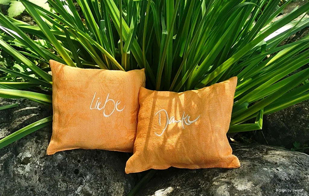 Das Bild zeigt kuschelige Kissen mit inspirierenden Botschaften auf der Vorderseite aus dem Onlineshop SignShop Tirol. Die Kissen sind mit duftenden Zirbenflocken gefüllt und laden zum Entspannen, Wohlfühlen und Träumen ein.