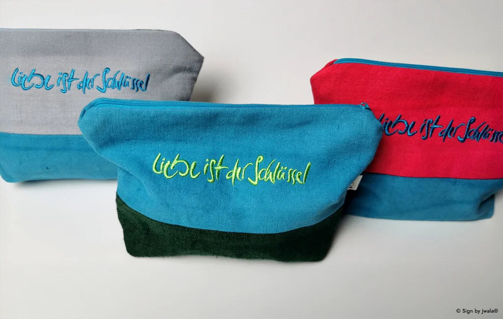 Hochwertige, bunte Kosmetikbeutel aus Bauernleinen mit der liebevollen Botschaft „Liebe ist der Schlüssel“, handgefertigt im SignShop Tirol.