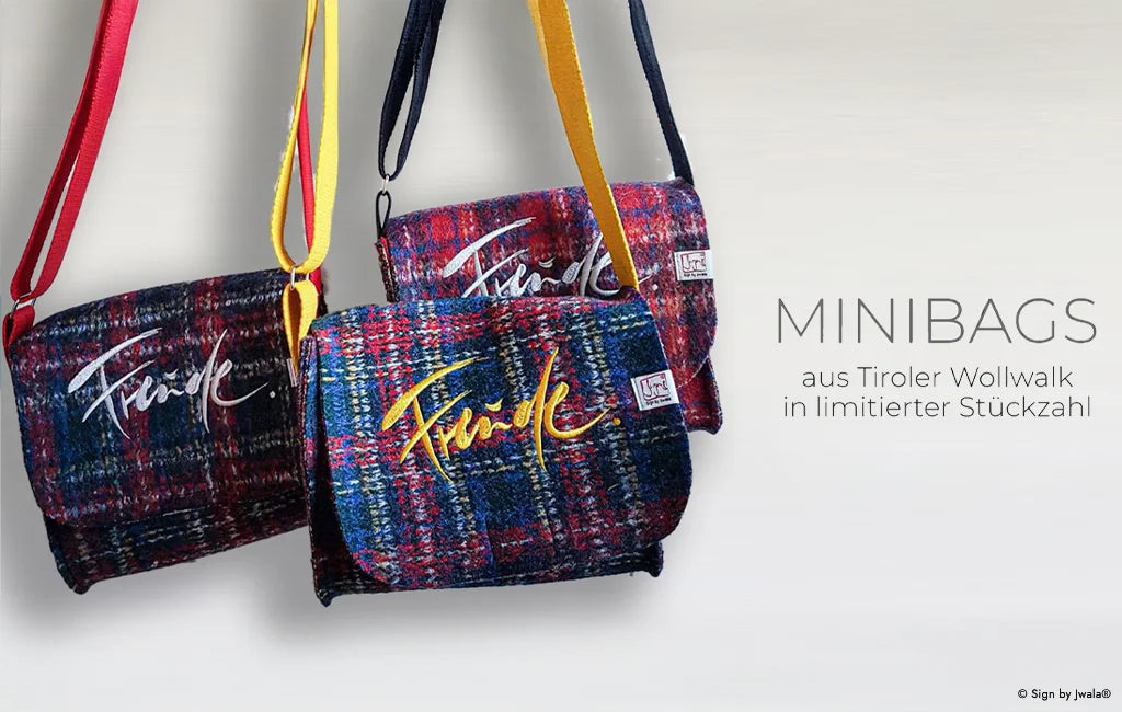 Bunte Tragetaschen und Minibags aus Bauernleinen mit der Botschaft „Freude“ aus dem SignShop Tirol.