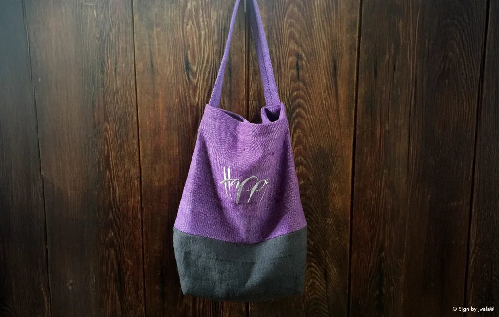 Lila und Blaue Tragetasche aus Bauernleinen mit der Botschaft „Happy“ aus dem SignShop Tirol.