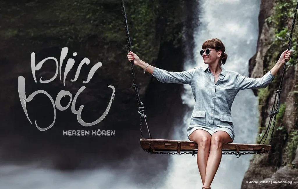 Frau auf einer Schaukel vor einem Wasserfall mit dem Schriftzug „Jwala® bliss bow – Herzen hören“ aus dem Onlineshop SignShop Tirol.