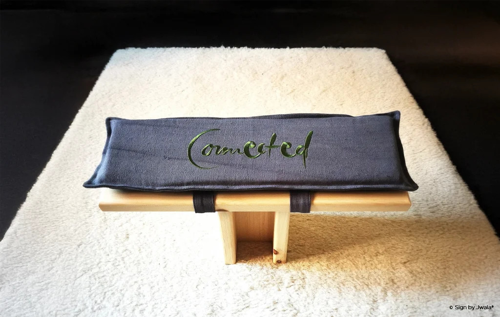 Meditationshocker aus Zirbenholz auf einem weißen Teppich mit SignKissen und inspirierender Botschaft aus dem Onlineshop SignShop Tirol.