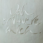 Detailaufnahme der cremefarbenen Stickerei „Ich erinnere mich.“ (Sign by Jwala®) auf naturfarbener Bauernleinen-Kissenhülle mit sichtbarer Struktur
