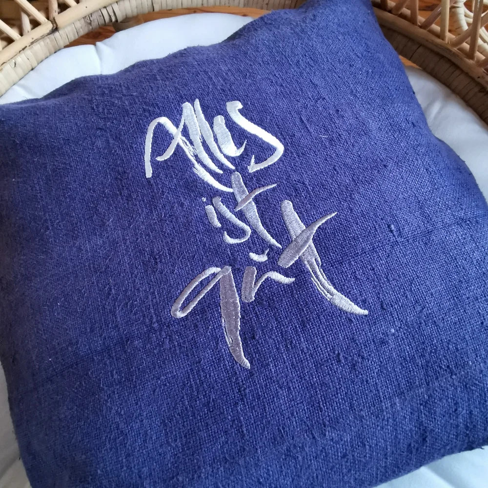 Flach liegende Kissenhülle „Alles ist gut“ aus handgewebtem Bauernleinen, 40x40 cm, mit sichtbarer Leinenstruktur und dezenter Silber-Stickerei
