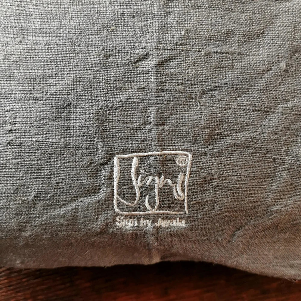 Detailaufnahme der Stickerei „Ich bin eine Meisterin, die übt.“ (Sign by Jwala®) in Silber und Gold auf grauer Bauernleinen-Kissenhülle