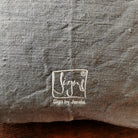 Detailaufnahme der Stickerei „Ich bin eine Meisterin, die übt.“ (Sign by Jwala®) in Silber und Gold auf grauer Bauernleinen-Kissenhülle