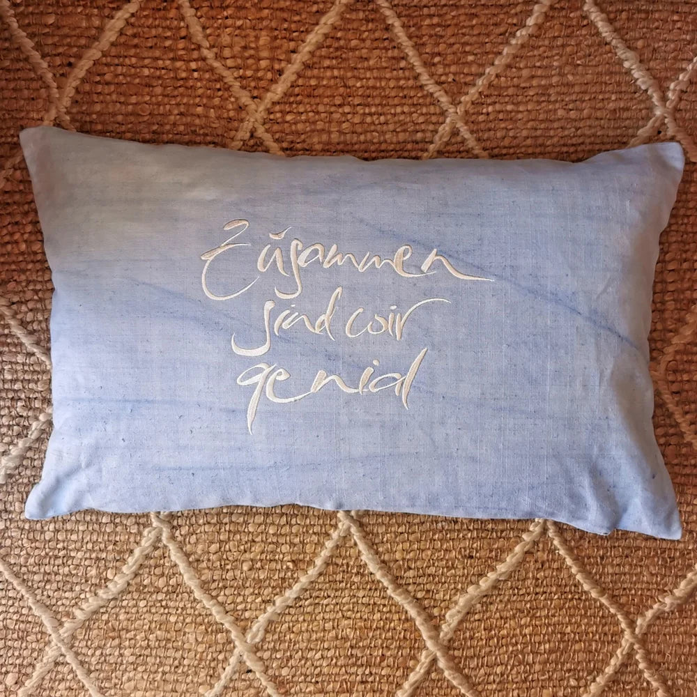 Flach liegende Kissenhülle „Zusammen sind wir genial“ mit Reißverschluss, 59x38 cm, präsentiert als limitierte, nummerierte Edition aus Tirol