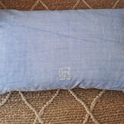 Hellblaue Kissenhülle „Zusammen sind wir genial“ aus handgewebtem Vintage-Bauernleinen, 59x38 cm, als edles Deko-Unikat auf einem Sofa arrangiert