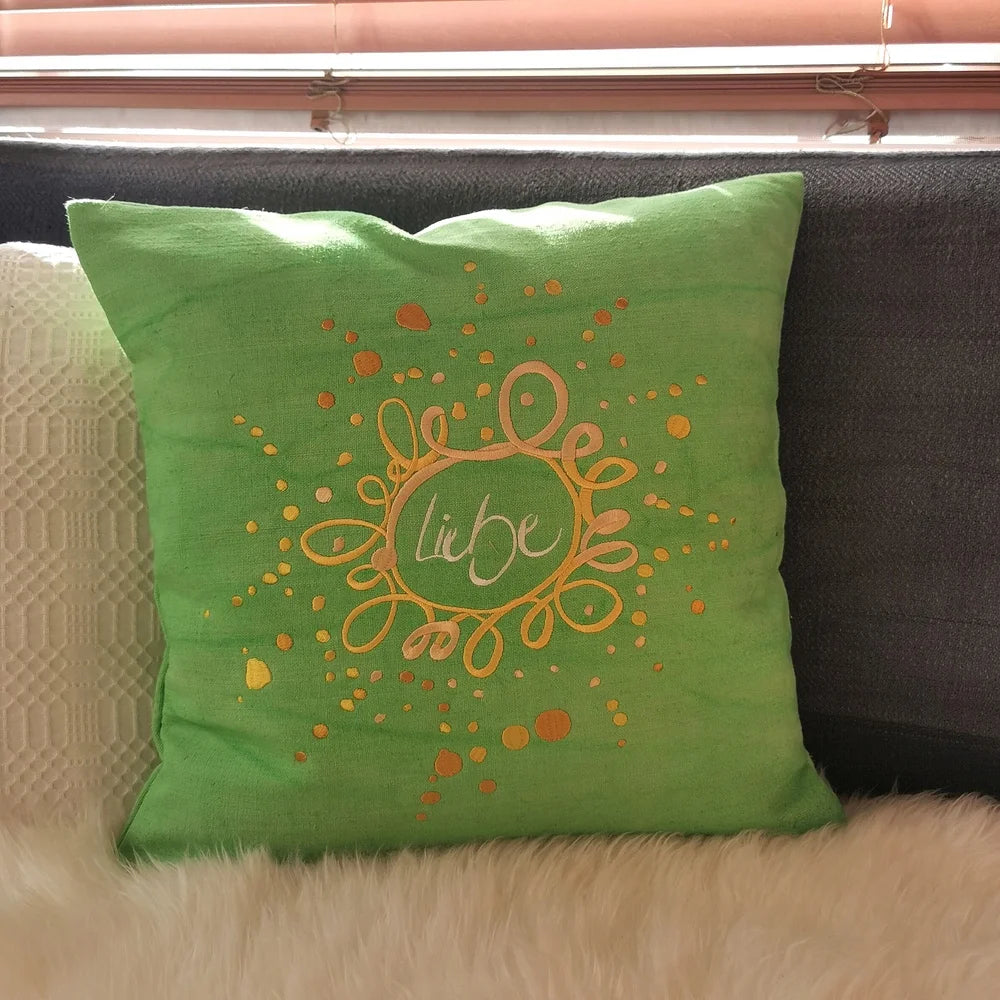 Hellgrüner Sitzpolsterbezug „Liebe/Ornament“ aus handgewebtem Vintage-Bauernleinen, 40x40 cm, als edles Deko-Unikat auf einem Stuhl arrangiert