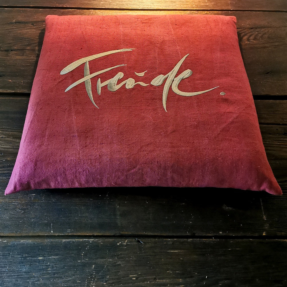 Genieße jeden Tag ein Stück Wohlbefinden mit dem handgemachten Flachkissen „Freude“, kunstvoll bestickt in edlem Beige und gefertigt aus hochwertigem, weinrotem Bauernleinen – perfekt zum Online-Bestellen.