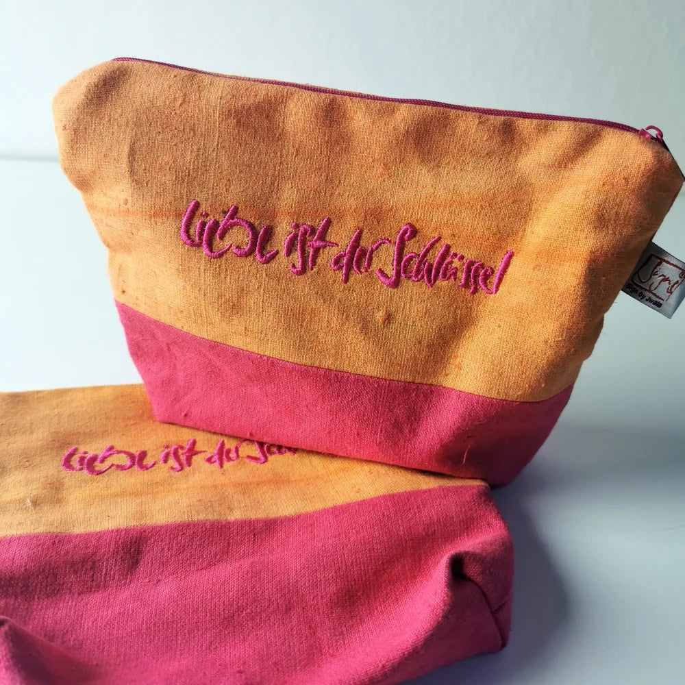 Farbige Kosmetiktasche mit inspirierender Stickerei in Magenta