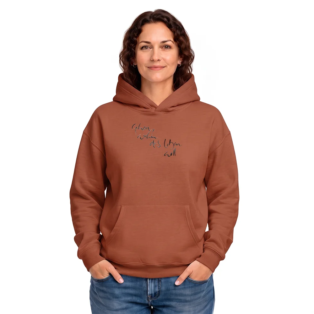 Frau im oversized Kapuzenpullover in Heritage Brown mit einem mehrzeiligen, feinen Sign "Gehen wohin das Leben will" auf der Vorderseite.