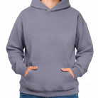 Schlichter Kapuzenpullover in zeitlosem Violet ohne Sign mit den Händen in der Kängurutasche.