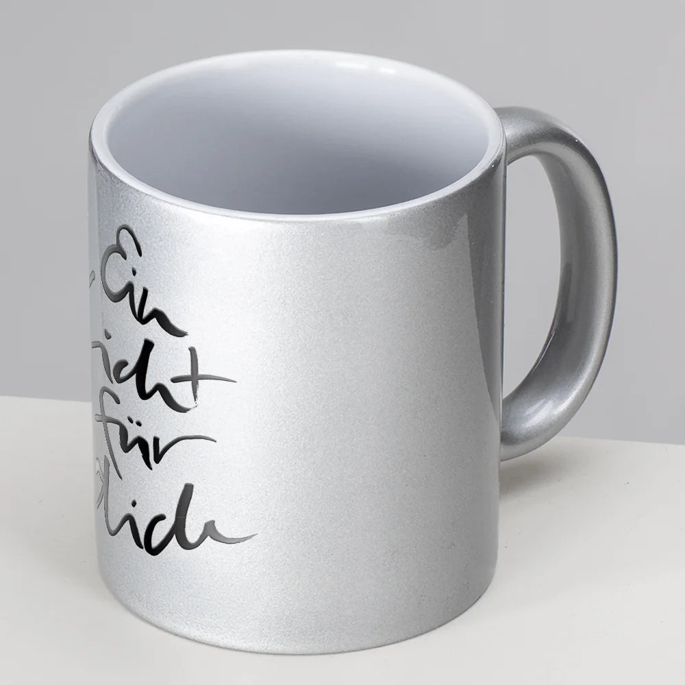 Silber glänzende Tasse aus Keramik mit dem vertikalen schwarzen Schriftzug Sign by Jwala® "Ein Licht für dich" in geschwungener Handschrift.