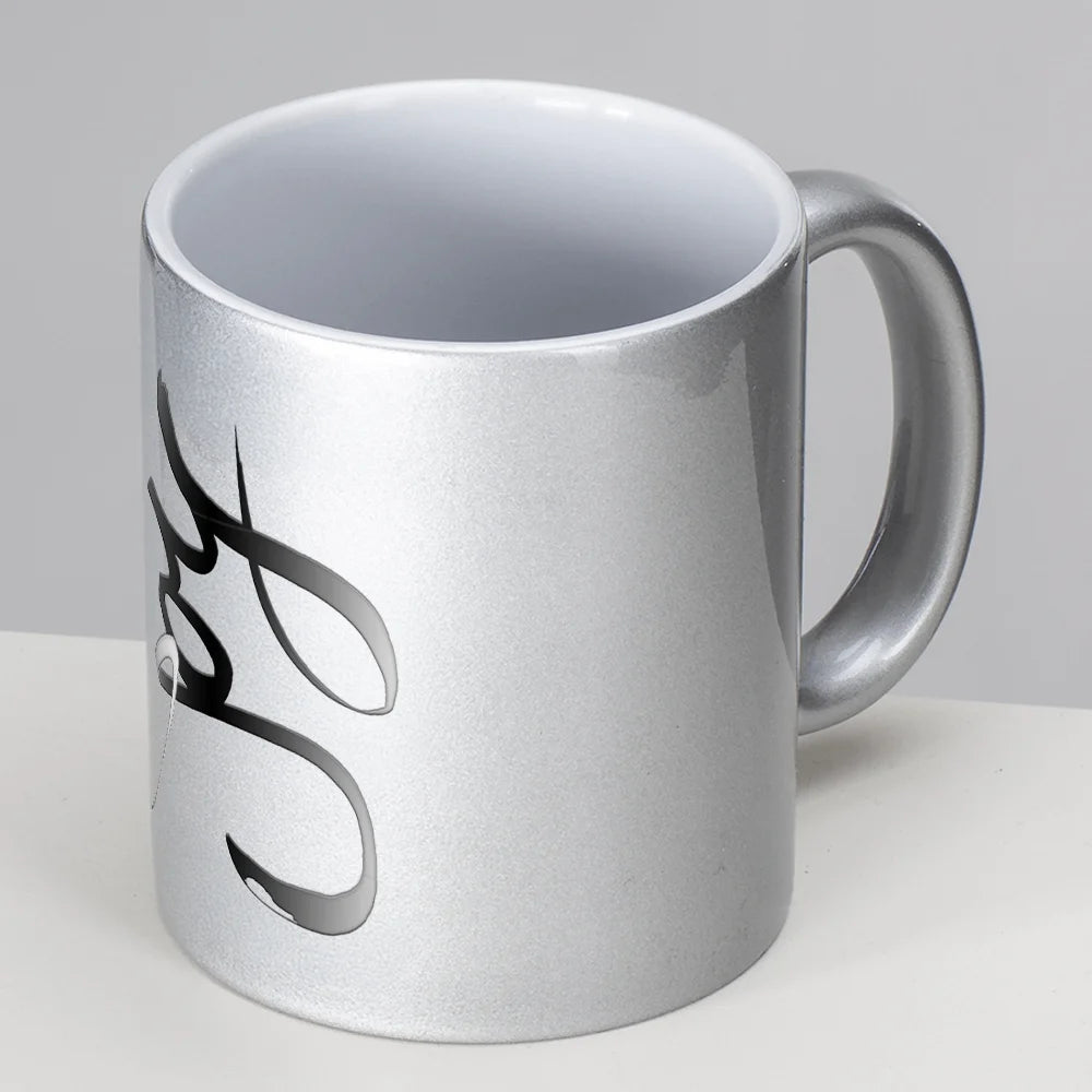 Detailansicht einer silbernen Metallic-Tasse mit dem schwarzen, geschwungenen Schriftzug Sign by Jwala® "Joy" an der Seite.