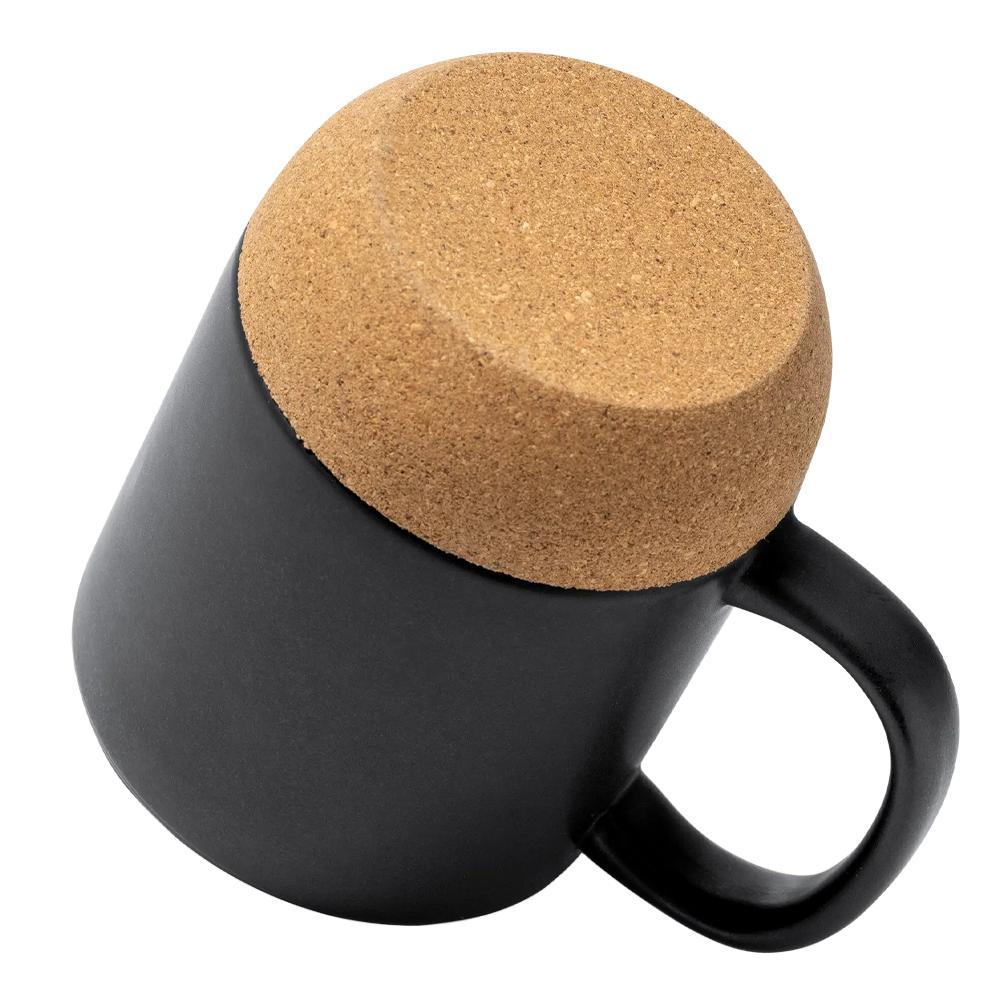 Liegende schwarze Keramiktasse mit Blick auf die Unterseite aus natürlichem, isolierendem Korkboden.