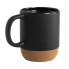 Große schwarze Keramiktasse mit Korkfuß und Henkel, Blick leicht von oben auf den glänzenden schwarzen Innenrand.