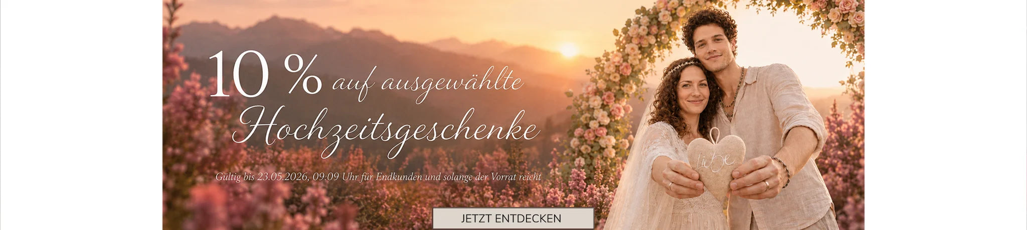 SingShopTirol Aktion: 10% Rabatt auf ausgewählte Hochzeitsgeschenke. Ein Brautpaar hält ein Stoffherz in einer sommerlichen Bergkulisse.