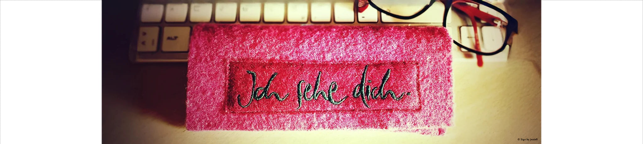 Rosa Brillentasche aus dem SignShop Tirol, liebevoll bestickt mit der Botschaft „Ich sehe dich“.