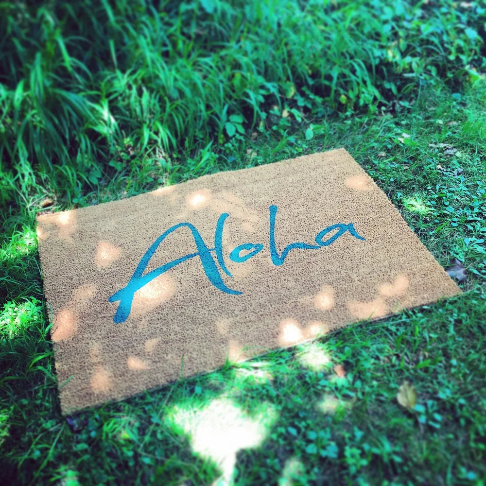 Handgemachte Fußmatte „Aloha“ in warmem Braun mit türkiser Schrift