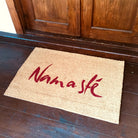Handgefertigte Namasté Fußmatte aus brauner Kokosfaser mit roter Aufschrift