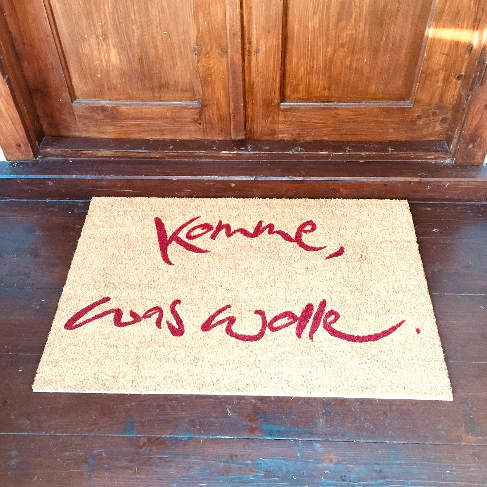 Spirituelle Fußmatte „Komme, was wolle“ aus brauner Kokosfaser mit roten Spruch