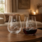 Ein 2er-Set der Riedel Sign-Gläser auf einem Holztisch in einem gemütlichen Wohnzimmer – ein Glas ist leer, das andere mit Rotwein gefüllt.