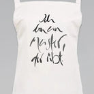 Weiße Latzschürze mit dem Titan farbenem Jwala® Sign „Ich bin ein Meister, der übt“ in ausdrucksstarker Kalligrafie – personalisierte Schürze online kaufen bei SignShop.tirol.