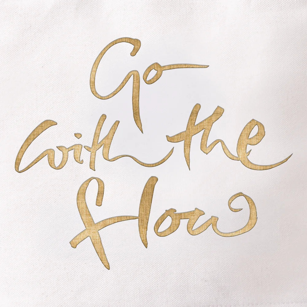 Detailansicht des goldenen Digitaltransferdrucks auf weißem Canvas-Stoff mit der inspirierenden Botschaft „Go with the flow“ in geschwungener Handschrift.